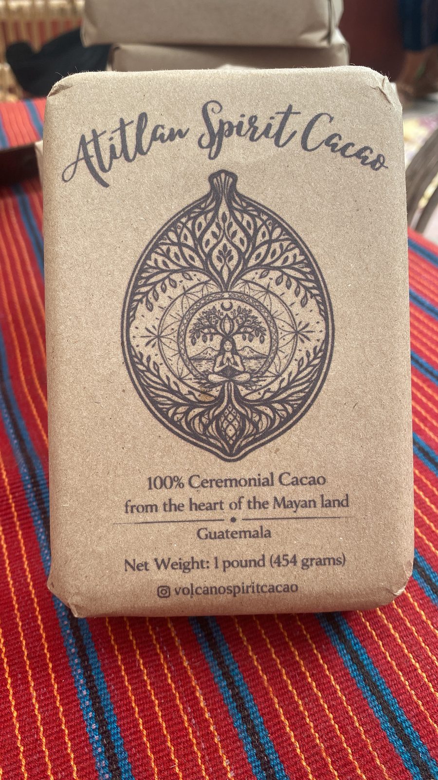 A 454g block of Volcano Spirit ceremonial cacao wrapped in kraft paper